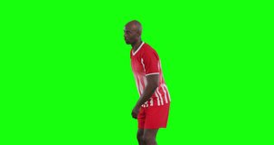 Video of african american male soccer player kicking ball on green screen background. Soccer, football, sports and competition concept.
