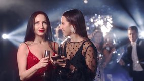 Drunk girlfriends chatting at a party and browsing social networks on a mobile smartphone during a party celebrating new year, christmas
