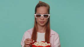 Excited teenager girl eating popcorn and watching interesting tv serial, sport game film, online social media movie content online. Student child kid on blue background enjoying domestic entertainment
