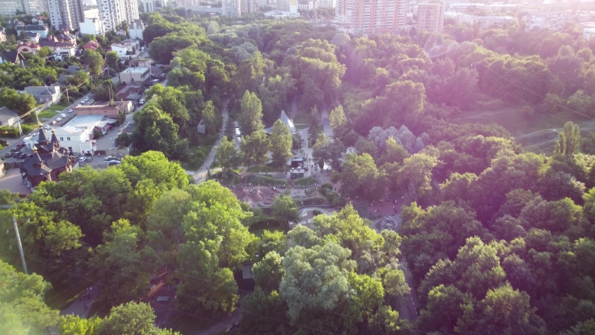 Aerial evening tilt-down view on water spring in green summer Kharkiv city center recreation park Sarzhyn Yar. Botanical garden with water spring and playground Royalty-Free Stock Footage #1093554881
