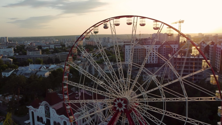 Ferris wheel spinning aerial top view in Kharkiv city center, amusement Gorky Park . High attraction for recreation and city observation Royalty-Free Stock Footage #1093554941