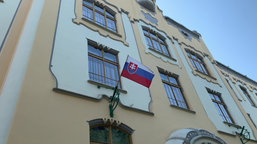 Slovak flag is waiving on governmental building wall at Bratislava city centre, old town. Motion of flag. Bratislava, Slovakia