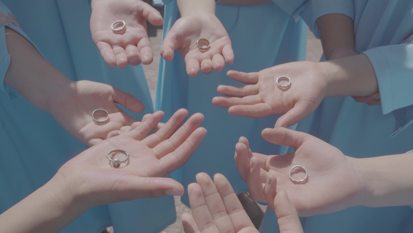 hands opening with rings in the palm of a group of girls