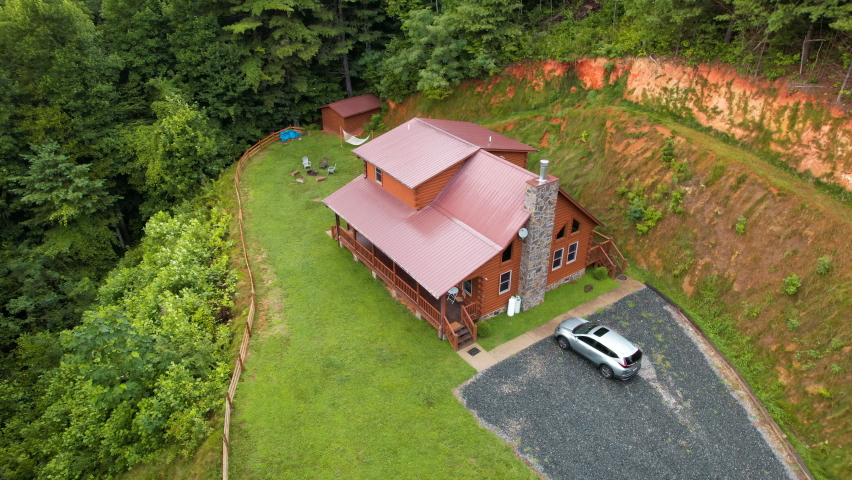 Log cabin. Wooden home. House exterior. Log cabin in Great Smoky Mountains North Carolina. Scenic view. Great for vacation. Country landscape with cottage. Green forest on background. Pine trees.