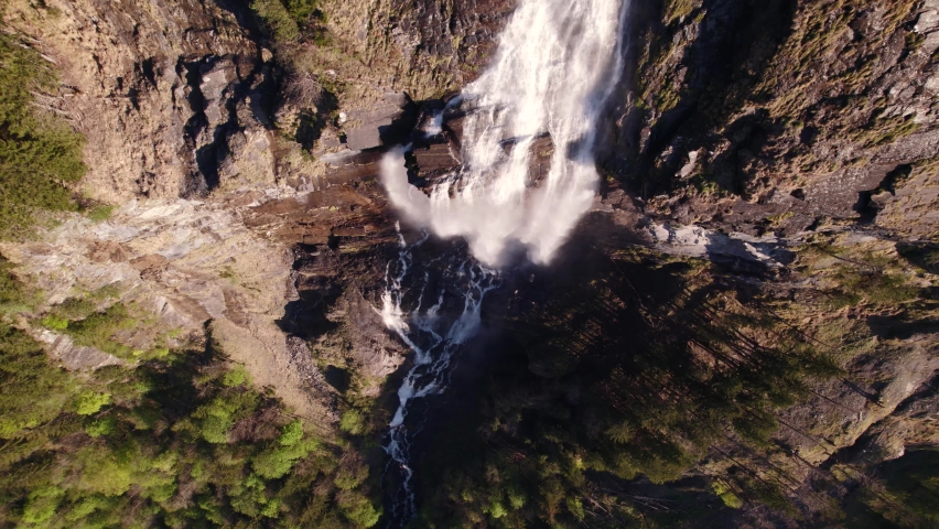 aerial drone footage raising up top down view of a dreamy waterfall in Grindelwald in the Swiss Alps