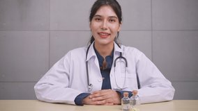 Asian woman doctor talking with patient via video call conference.