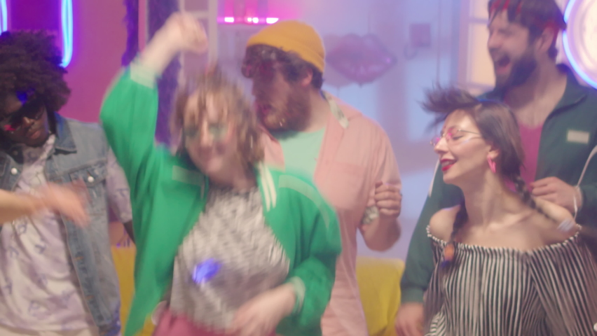Sequence of shots of excited multiethnic friends in bright outfits dancing, having fun and popping party cannon at disco | Shutterstock HD Video #1093586701