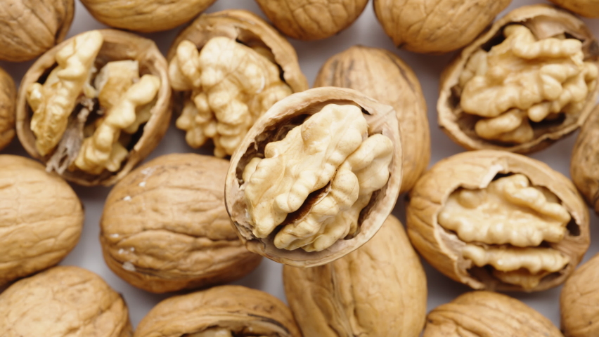 Walnut, split in half, rotates, nuts at the bottom. close-up.