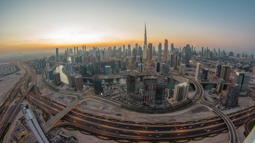 Panoramic skyline of Dubai with business bay and downtown district day to night timelapse. Aerial wide angle view of many modern skyscrapers with traffic on al khail road after sunset. Royalty-Free Stock Footage #1093600169