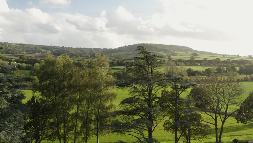 Rural Green Fields, Trees And Mountains In Honiton, Devon, UK. - aerial slider