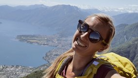 Young woman taking a video selfie on mountain top 