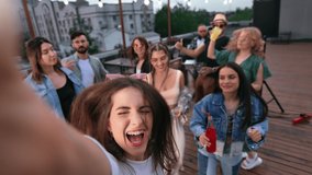 Woman blogger vlogger shooting POV selfie video photo at roof party smiling dancing with friends. Hipster man and woman dance jumping drinking cocktails alcohol night club event music discotheque  - Powered by Shutterstock - Get 15% off with code: PIKWIZARD15