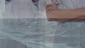 Animation of data processing over happy diverse male and female doctors using tablet. Health, medicine, data processing and technology concept digitally generated video.