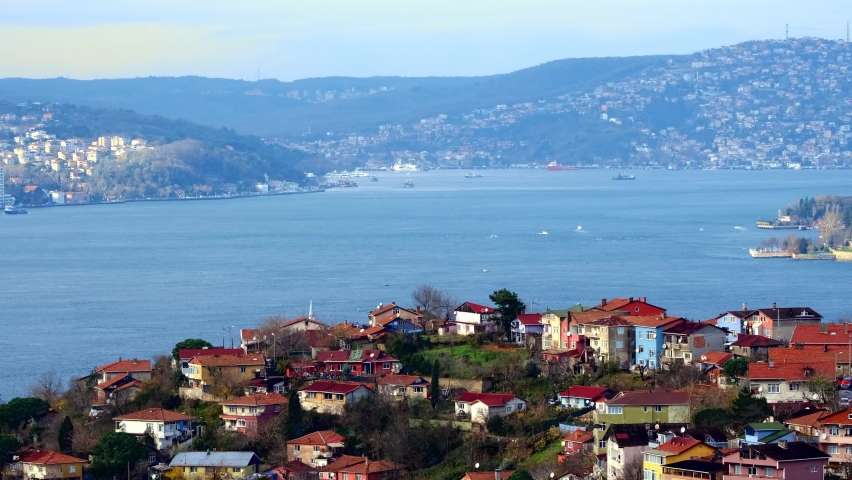 Life and ships, maritime traffic on the shores of an island with traditional and modern houses. Ferries sail along bosphorus. Endless rows of houses and majestic mosques. İstanbul, Turkey.