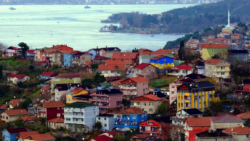 Life and ships, maritime traffic on the shores of an island with traditional and modern houses. Ferries sail along bosphorus. Endless rows of houses and majestic mosques. İstanbul, Turkey.