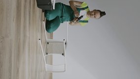 Female is assembling a chair. Vertical video