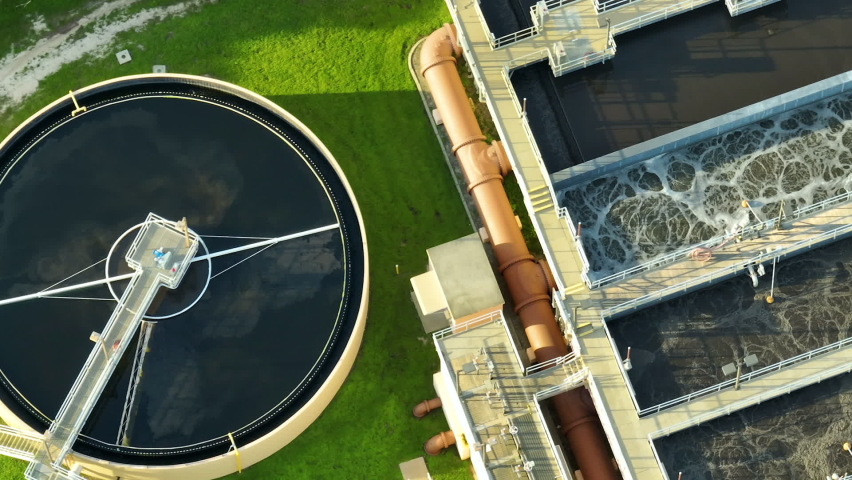 Aerial view of modern water cleaning facility at urban wastewater treatment plant. Purification process of removing undesirable chemicals, suspended solids and gases from contaminated liquid Royalty-Free Stock Footage #1093651959