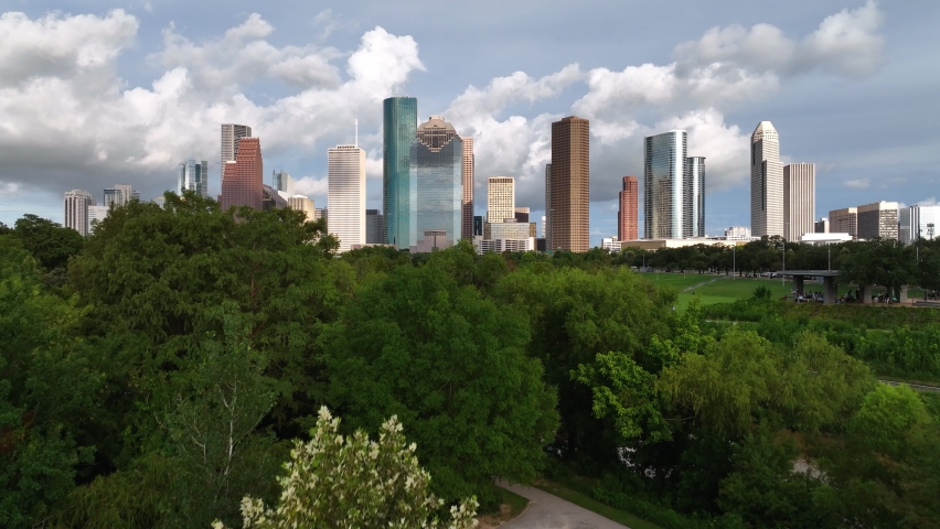 Aerial view rising over the Buffalo bayou river, towards skyscrapers in Houston city