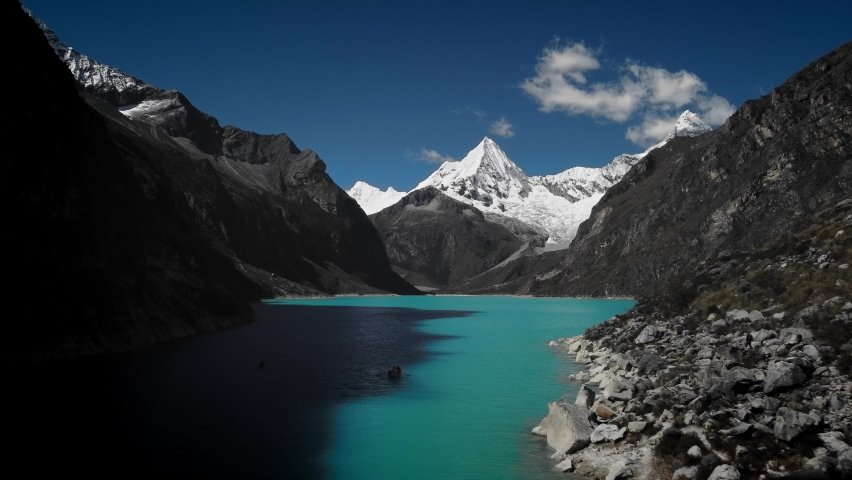 Drone flying over a blue lake Paramount Pictures' snow-capped mountain at Laguna Paron, Huaraz, Peru Royalty-Free Stock Footage #1093655521