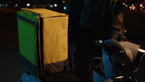The deliveryman arrived on a scooter to the house and goes to give the order to the client. Video without noise and artefacts