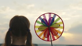 happy child with spinner toy sunset background. girl childhood dream. child park with windmill. pinwheel child hand outdoors. color pinwheel concept. small child park plays spinner toy. happy family - Powered by Shutterstock - Get 15% off with code: PIKWIZARD15