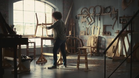 Young Female Furniture Designer Entering Workshop, Starting to Assemble a Wooden Chair with Rubber Hammer. Stylish Multiethnic Woman Working in Loft Studio with Tools on Walls. Video stock