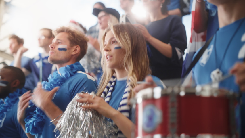 Sport Stadium Big Event: Beautiful Cheering Girl. Crowd of Fans with Painted Faces Cheer, Shout for their Blue Soccer Team to Win. People Celebrate Scoring a Goal, Championship Victory. Slow Motion