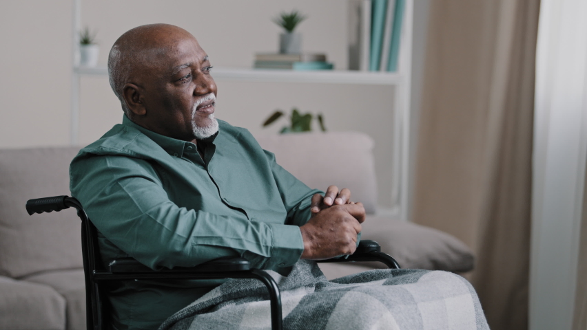 Pensive dreaming calm alone elderly patient. old African bald man with gray beard senior mature grandpa sit on wheelchair at home looking away dreams thinking ponders deep in memories Alzheimer sick Royalty-Free Stock Footage #1093681581