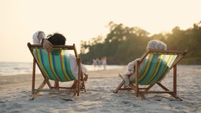 Happy Asian family senior couple enjoy outdoor lifestyle on summer beach holiday vacation at the sea. Elderly retired man and woman relaxing on beach chair and holding hands together at summer sunset - Powered by Shutterstock - Get 15% off with code: PIKWIZARD15