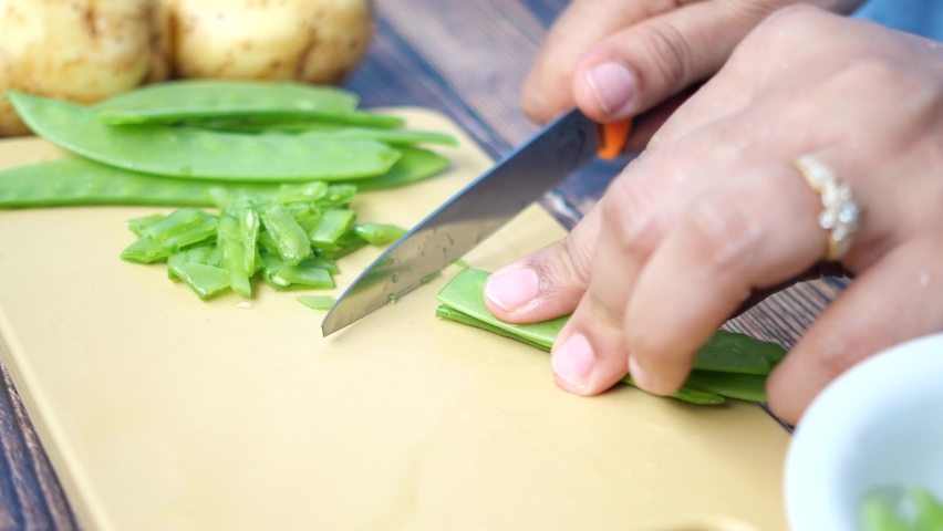 women cutting Holland beans on the cutting board