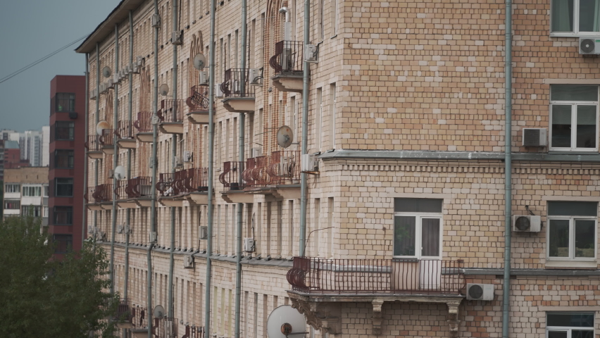Establishing shot on a busy street in one district of Moscow. View from the window to the street with busy traffic of cars and public transport in summer