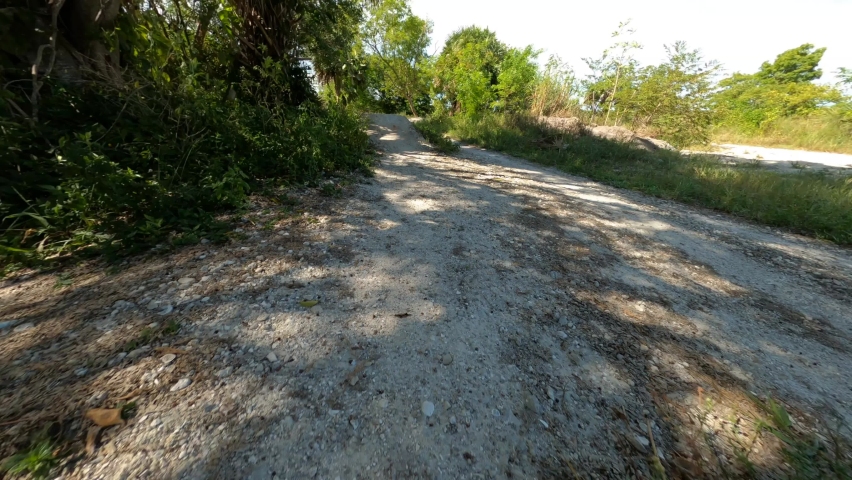 Subjective first-person point-of-view cycling over two small hills in a bike trail at Quiet Waters Park, Deerfield Beach, Florida in the afternoon sun