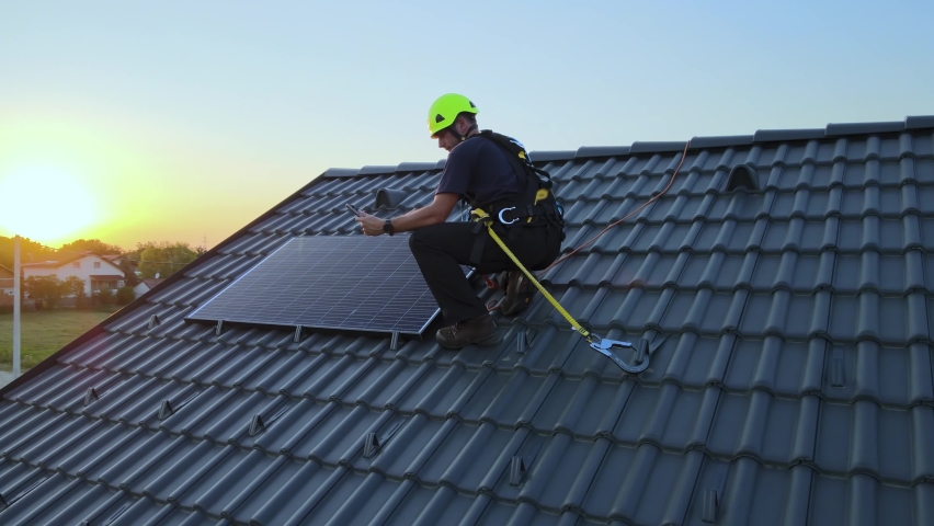 Engineer checking data on tablet, while installing solar panels on a private house roof - Aerial view Royalty-Free Stock Footage #1093701903