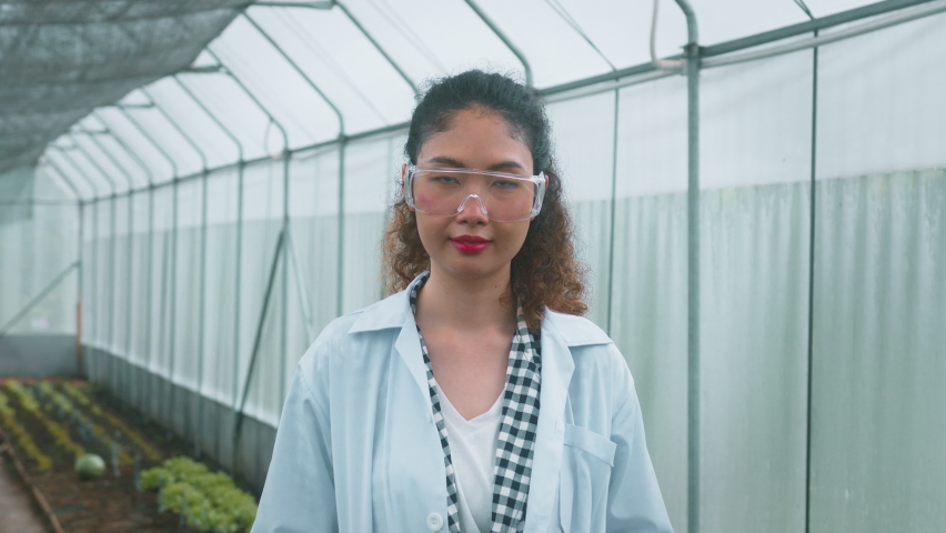 Asian female agronomist working in a greenhouse, organic vegetable and agriculture concept, an Industrial Video by Thanakorn.P