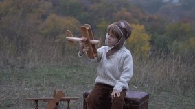 Slow Motion Little boy sits on a suitcase playing with model airplane - Powered by Shutterstock - Get 15% off with code: PIKWIZARD15