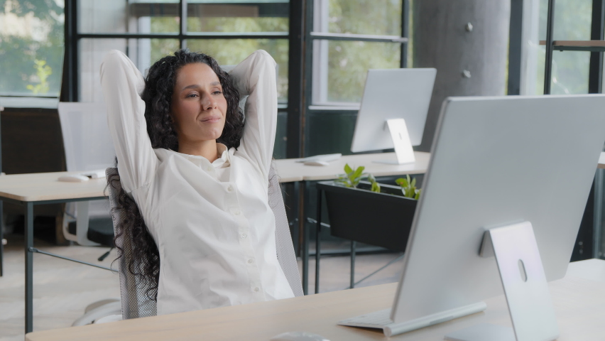 Relaxed woman manager taking break at workplace holding hands behind head resting after completing work sitting at desk dreaming with closed eyes enjoying relaxation feels satisfaction by work done Royalty-Free Stock Footage #1093708007