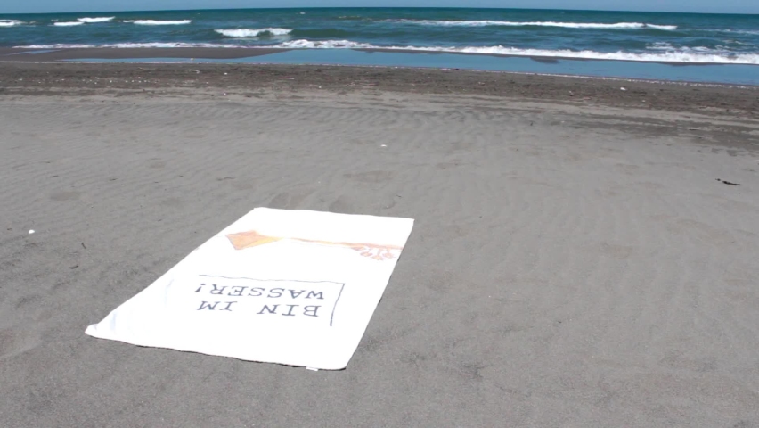 Man relaxing on beach and walking on sand, man sitting on sand and walking through to sea, selective focus 
