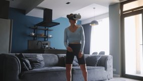 Futuristic girl funny dancing in VR headset for social media platform media in living room at home. Woman avatar performing in metaverse cyberspace immersive experience for followers audience.