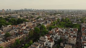 Narrow streets of the historic center of Amsterdam with traditional houses on both sides of the canal. Video from a bird's eye view, from a drone