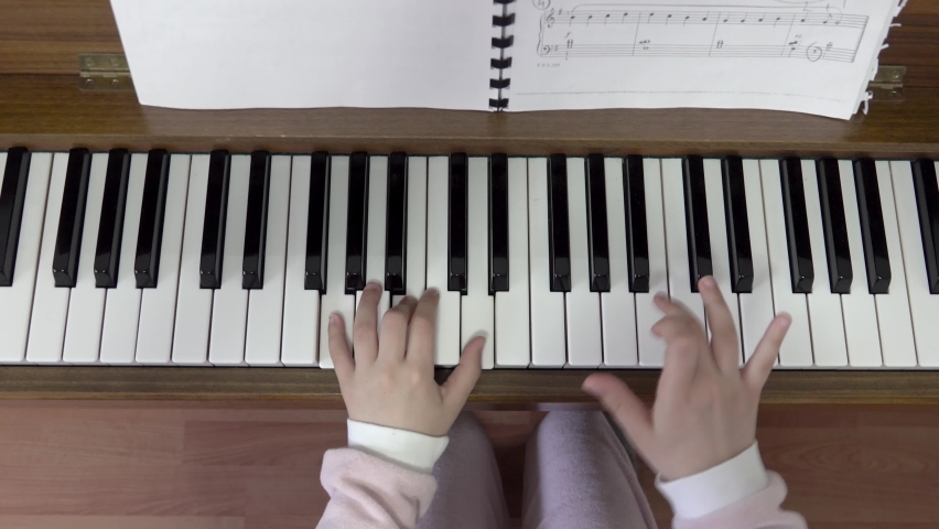 Child playing piano. Close up on piano keys, child hands and fingers. Slider view of playing Royalty-Free Stock Footage #1093722567