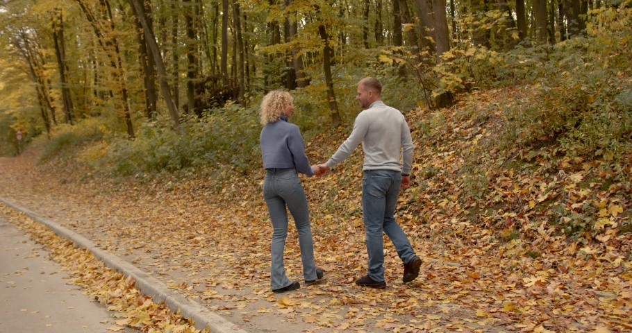 Loving couple in jeans on a date in the autumn park