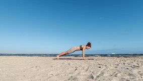 4k slow motion video of a girl doing morning yoga routine  at the coastline of Baltic sea