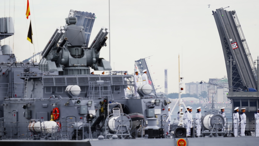 A lot of warships goes along the Neva River under open bridges at the time of the celebration of the day of Navy in cloudy weather, military motor boat