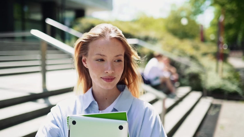 Pretty girl university student holding notebooks looking at camera posing for outdoor portrait. College study programs, academic educational courses ads, learning classes concept. Royalty-Free Stock Footage #1093742109