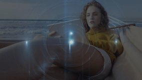 Animation of light beam with circle over caucasian woman using digital tablet on hammock at beach. Digital composite, multiple exposure, leisure activity, relaxation, wireless technology, vitality. - Powered by Shutterstock - Get 15% off with code: PIKWIZARD15