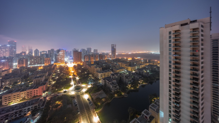 Skyscrapers in Barsha district and low rise buildings in Greens district aerial night to day transition timelapse. Dubai panoramic skyline foggy morning Royalty-Free Stock Footage #1093746155
