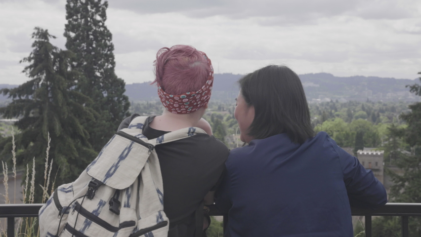 A happy LGBT couple looking out over the city of Portland, Oregon.