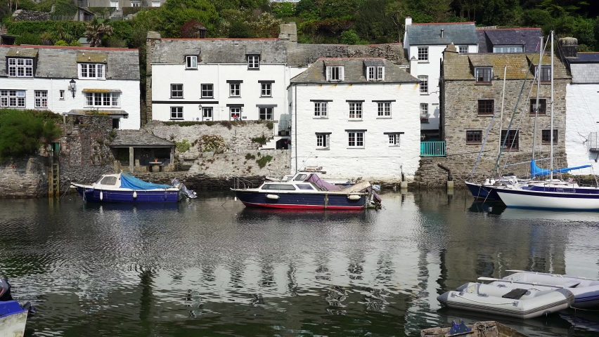 Fishing boats moored up in the quaint harbour of the historic fishing village of Polperro, Cornwall, England, UK