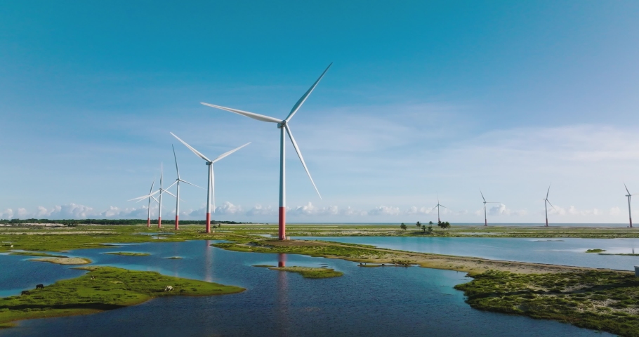Aerial view wind turbines in middle of wetlands in Maranhao, Brazil - low, tracking, drone shot Royalty-Free Stock Footage #1093758239