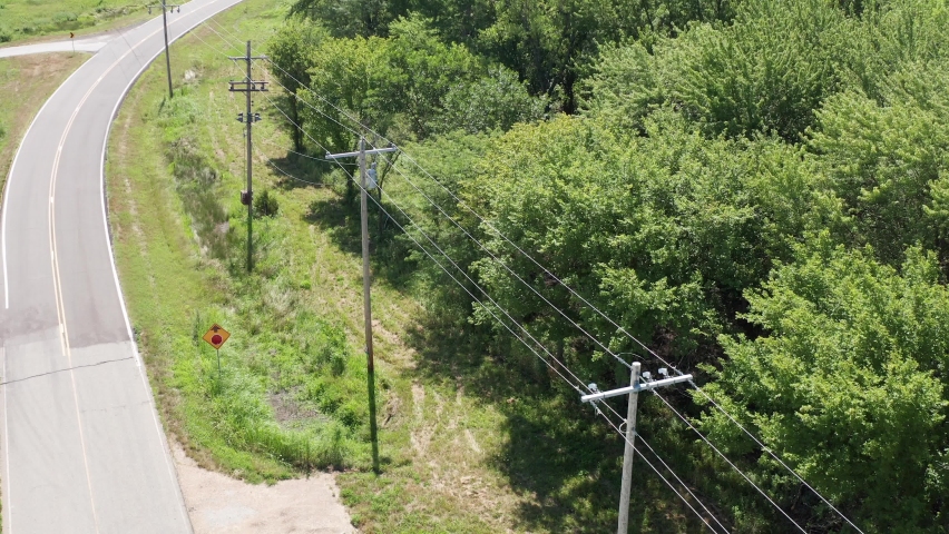 Close-up aerial shot flying over a rural utility pole and powerline inspection. 4K Royalty-Free Stock Footage #1093758495